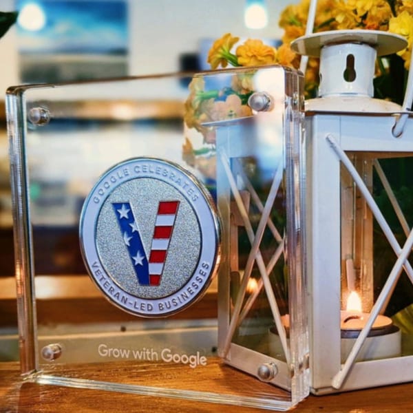 A Google award for veteran-led businesses next to a white lantern with a lit candle.
